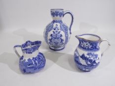 Three blue and white jugs / ewers of graduated size comprising a Gien faience example decorated in