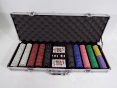 A cased poker set comprising chips, two decks of cards and dice.