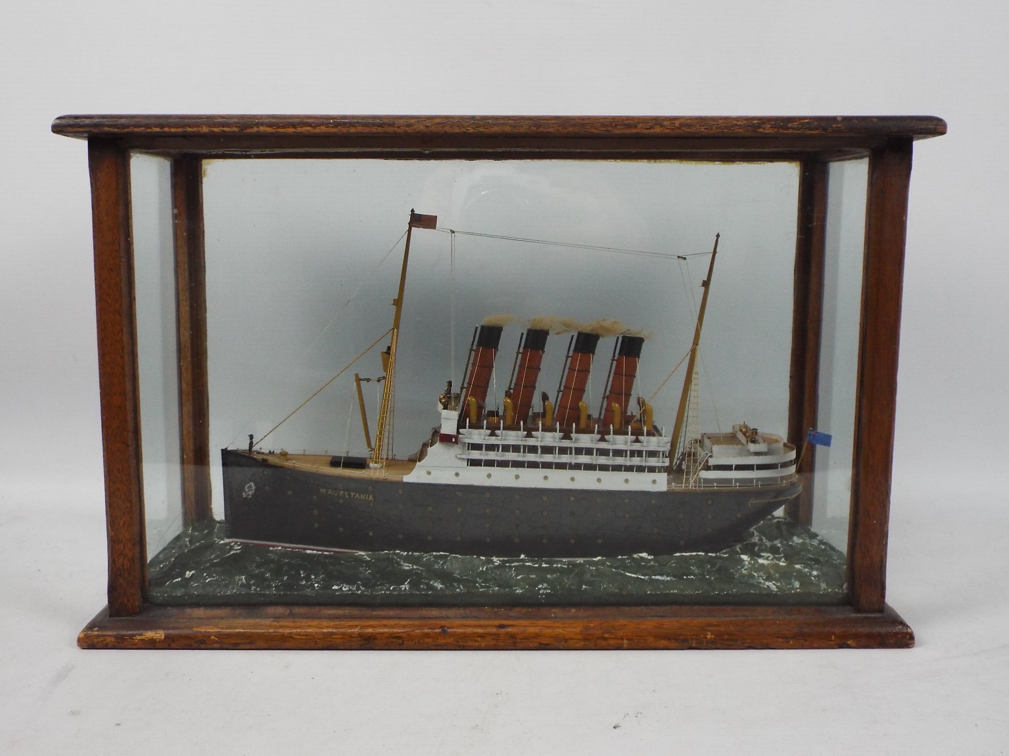 A scratch built model ship in glazed display depicting RMS Mauretania,
