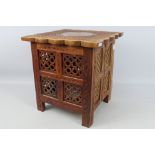 Ethnographica - A square section carved folding table with brass inlay and with enclosed storage ,