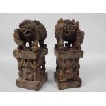 A pair of stone carvings depicting Buddhist lions raised on plinths, 21 cm (h).