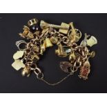 A 9ct rose gold charm bracelet, stamped 9ct, with numerous 9ct charms,