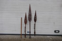 Ethnographica - Three carved wood tribal paddle spears, largest 146 cm (l) and a wooden ruler.