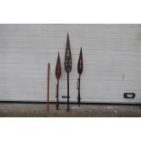 Ethnographica - Three carved wood tribal paddle spears, largest 146 cm (l) and a wooden ruler.