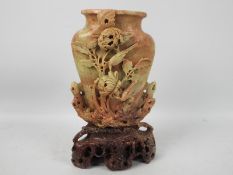 A carved soapstone vase, decoration of birds and flowers with naturalistic carved stand,