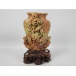 A carved soapstone vase, decoration of birds and flowers with naturalistic carved stand,