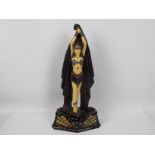 A large Art Deco style figure depicting an Egyptian style female with arms raised,