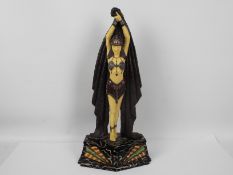 A large Art Deco style figure depicting an Egyptian style female with arms raised,