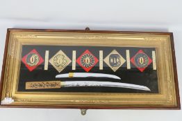 A decorative, framed and glazed sword display comprising five tsuba, tanto blade and wakizashi,