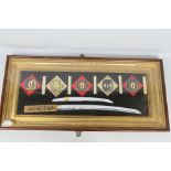 A decorative, framed and glazed sword display comprising five tsuba, tanto blade and wakizashi,