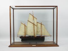A scratch built model of a three masted lugger in glazed display,