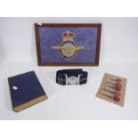 An embroidered Royal Air Force badge in framed display, vintage ejector seat keys, belt and other.