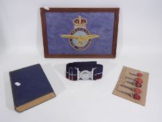 An embroidered Royal Air Force badge in framed display, vintage ejector seat keys, belt and other.