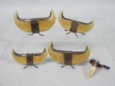 A set of four unusual menu holders, each formed from a pair of claws with white metal mounts,