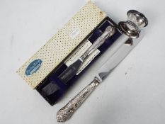 A silver handled butter knife, a further silver handled knife and a silver napkin ring.