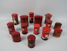 A collection of vintage tinplate money banks in the form of Post Office pillar boxes to include