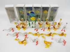 A collection of coloured glass animals comprising birds and fish.