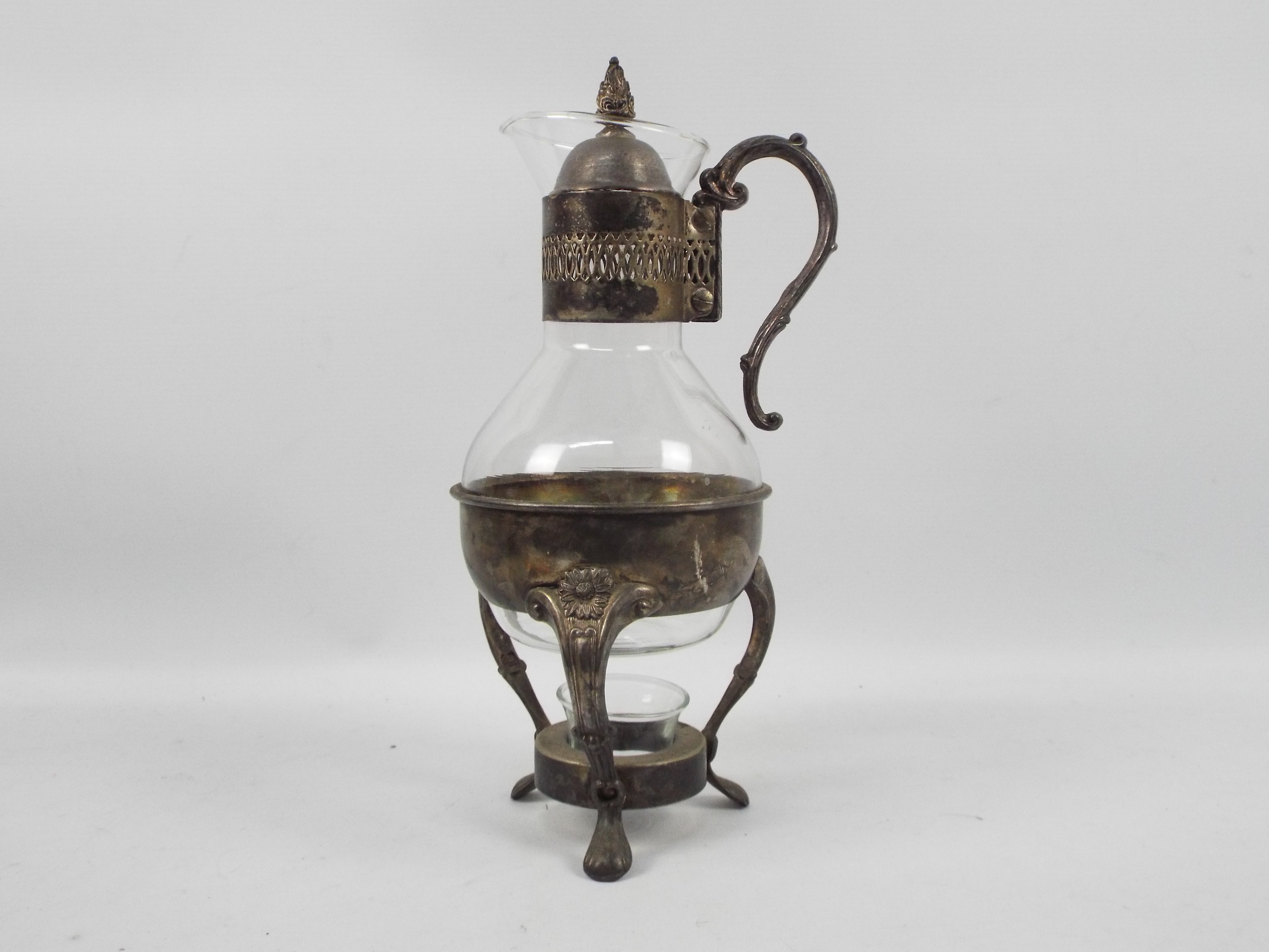 A glass and silver plate coffee pot with plated warming stand, approximately 35 cm (h).