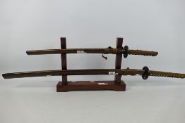 A decorative sword display comprising stand with katana and wakizashi.