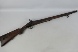 An early 19th century wall hanger percussion smoothbore rifle with heavy wooden sock and barrel