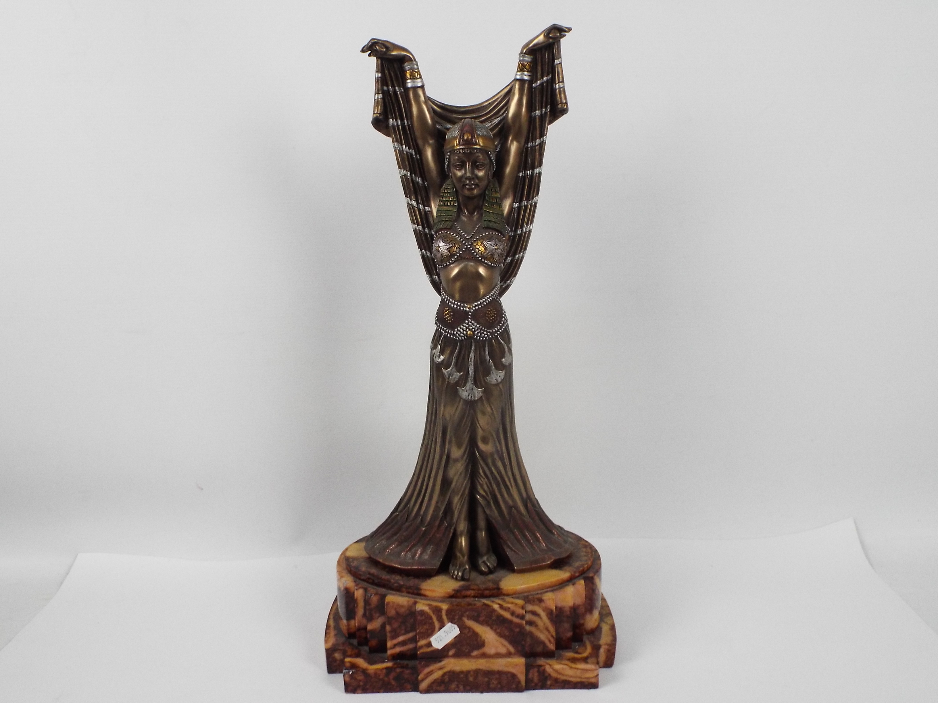 A large Art Deco style figure depicting an Egyptian style female with arms raised,