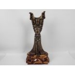 A large Art Deco style figure depicting an Egyptian style female with arms raised,