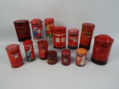 A collection of vintage tinplate money banks in the form of Post Office pillar boxes to include