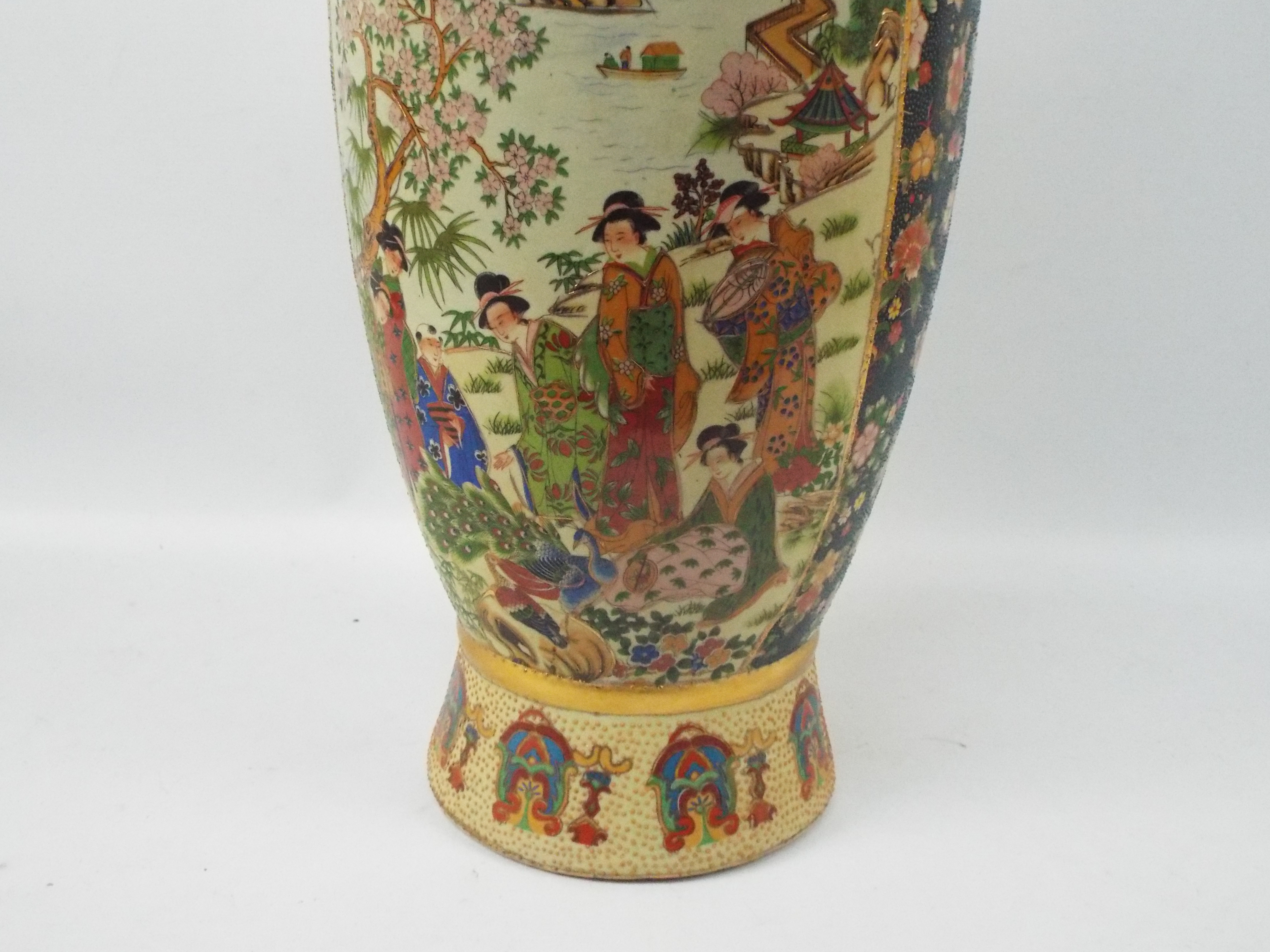 A large Japanese Satsuma ware vase with twin gilt handles decorated with two panels of figures in a - Image 3 of 10