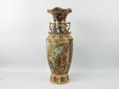 A large Japanese Satsuma ware vase with twin gilt handles decorated with two panels of figures in a