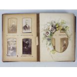 An antique album containing a collection of cabinet cards and cartes de visite.