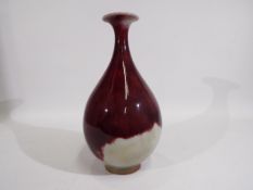 A sang de boeuf vase of ovoid form with everted rim, seal mark to the base, approximately 33 cm (h).