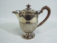 A late Victorian hallmarked silver coffee pot with gadrooned body, London assay 1896,