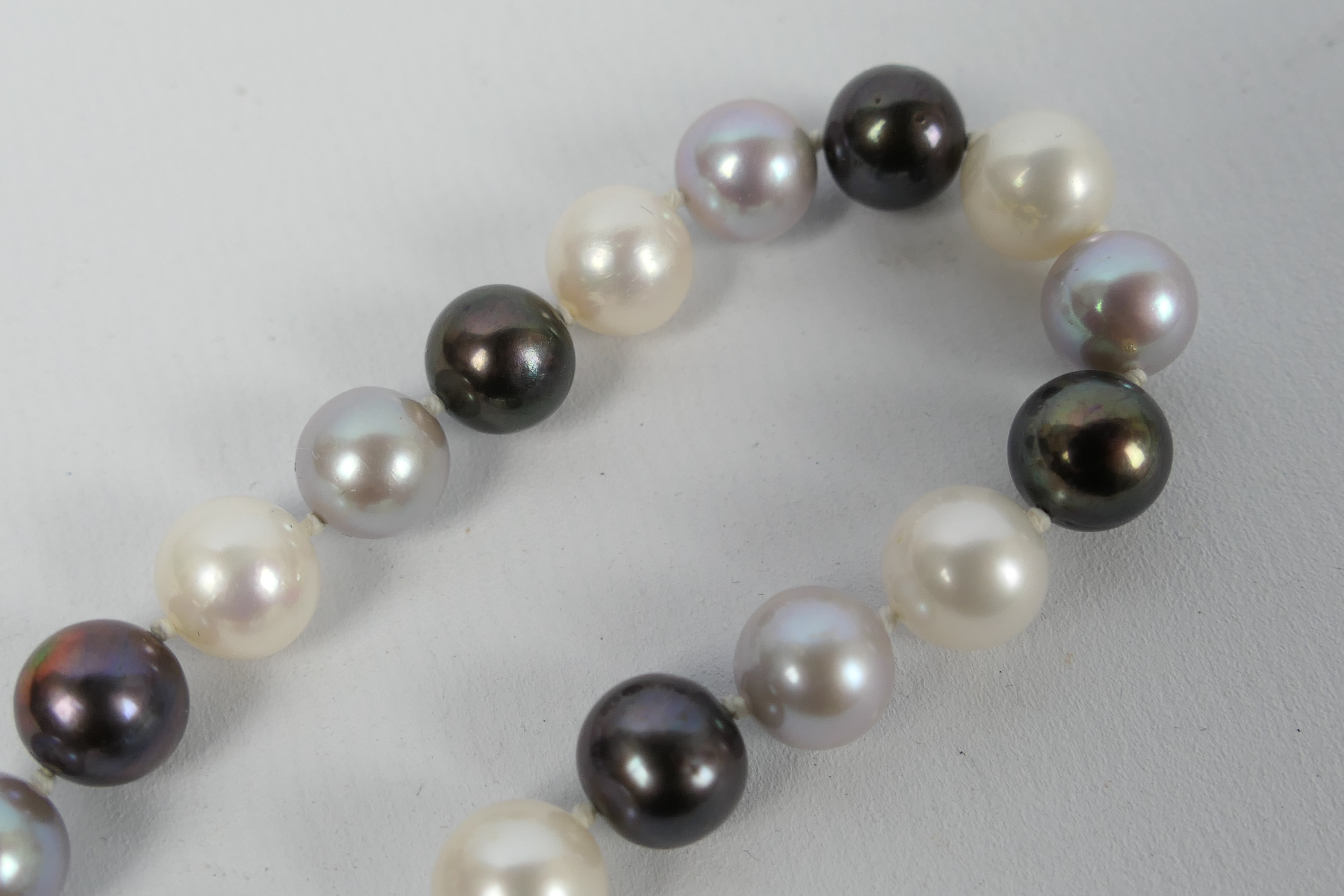 A pearl necklace compromising black, grey and white alternating pearls, each approximately 9 mm, - Image 6 of 6