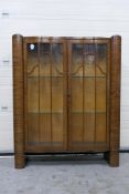 A twin door, serpentine front display cabinet with two glass shelves,