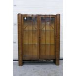 A twin door, serpentine front display cabinet with two glass shelves,