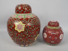 A large ginger jar and cover decorated with floral scrolls against a red ground,