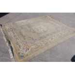 A large carpet with central medallion and floral border surround,