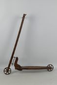 A vintage hand constructed wooden child's scooter with metal wheels, approximately 80 cm x 70 cm.