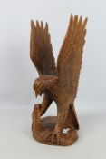 A large carved wood sculpture depicting an eagle attacking a cobra,