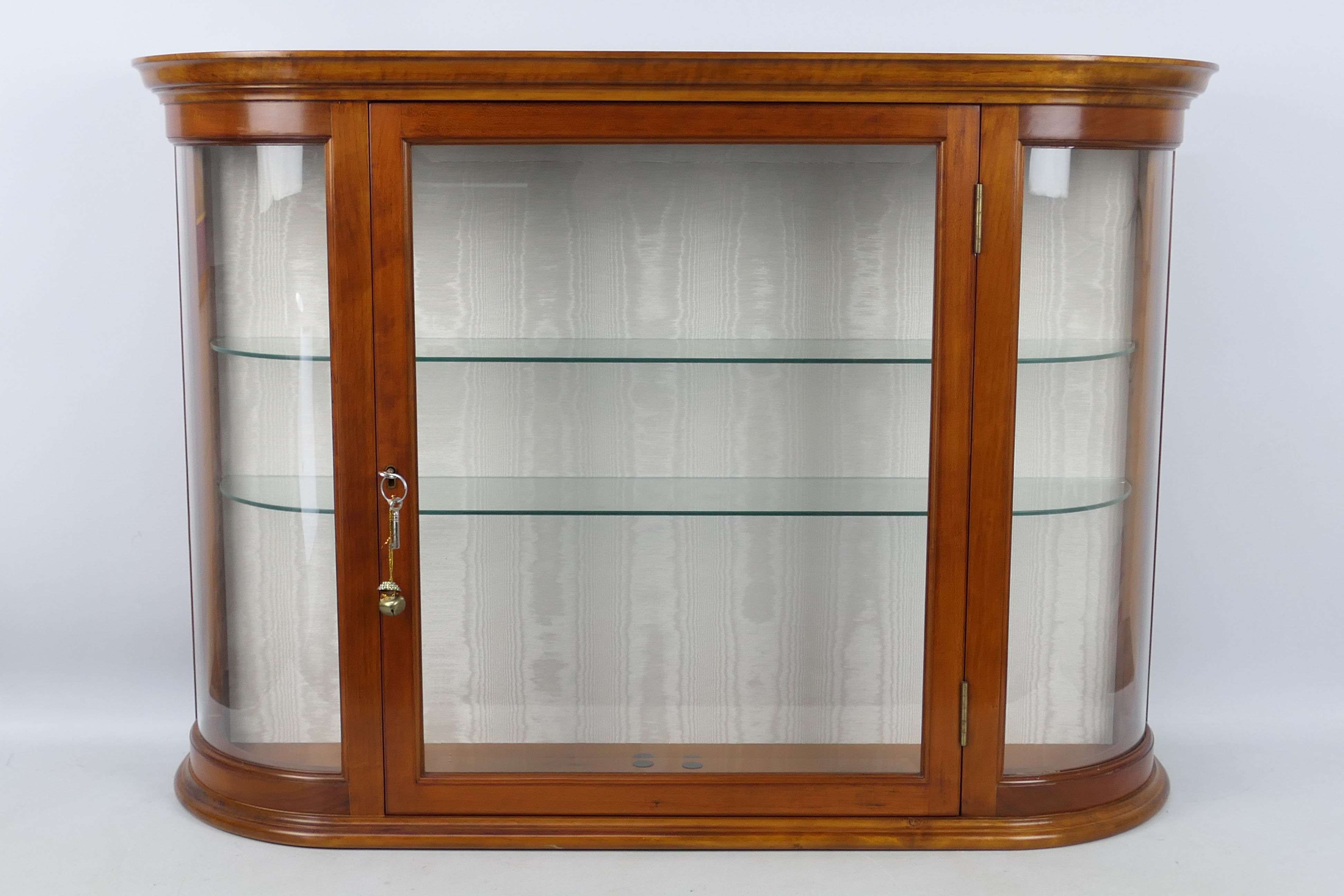 A good quality display cabinet with bevelled central pane, two glass shelves and two keys,