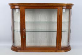 A good quality display cabinet with bevelled central pane, two glass shelves and two keys,