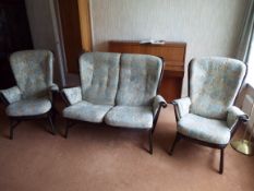 An Ercol three piece suite comprising a two seater settee and two armchairs.