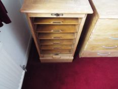 A vintage filing cabinet cabinet with rise and fall tambour door enclosing six slides,