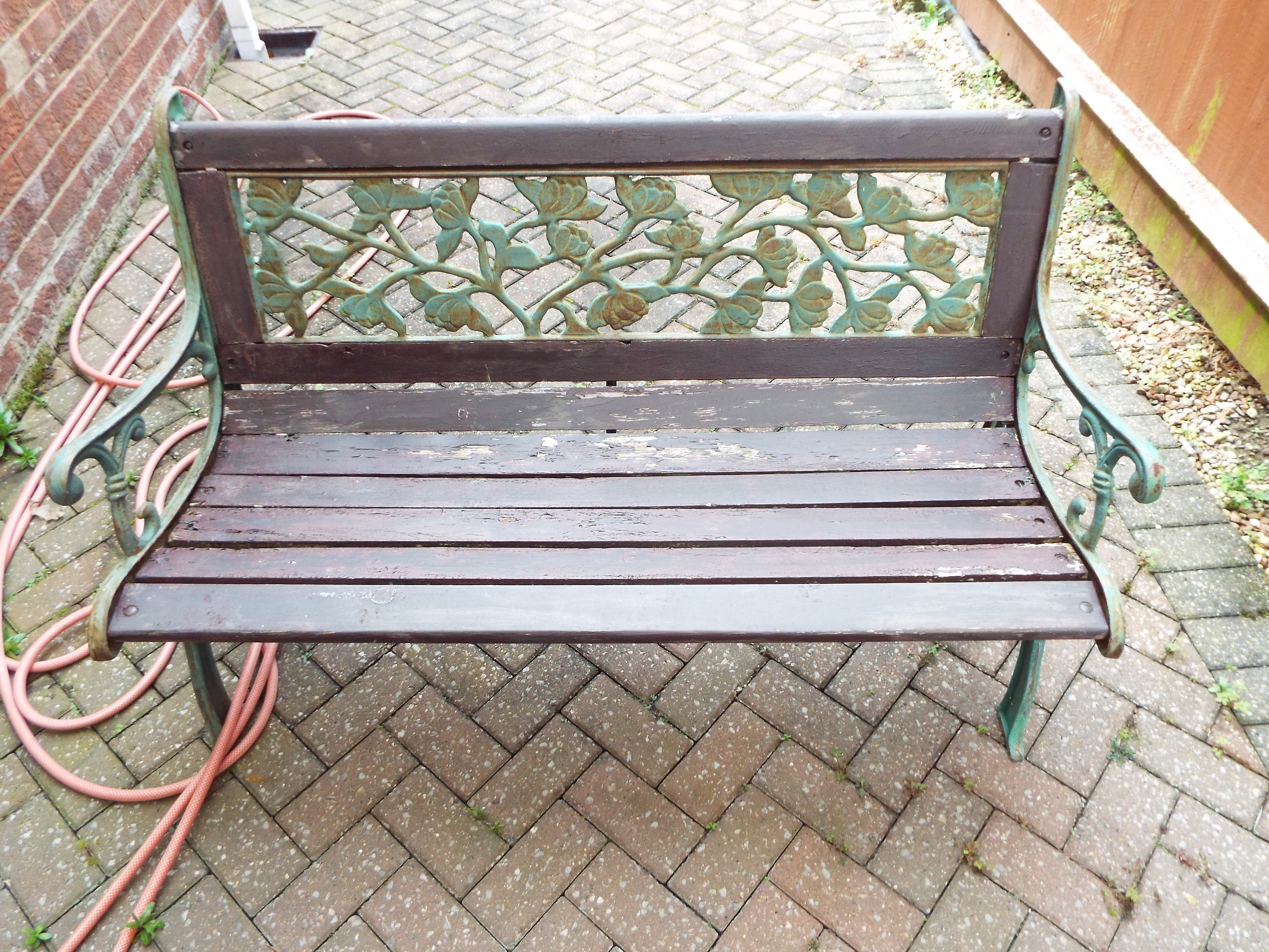 A cast metal and wood garden bench measuring approximately 75 cm x 127 cm 67 cm.