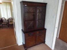 A display cabinet with twin astragal glazed doors over a twin door cupboard surmounted by two