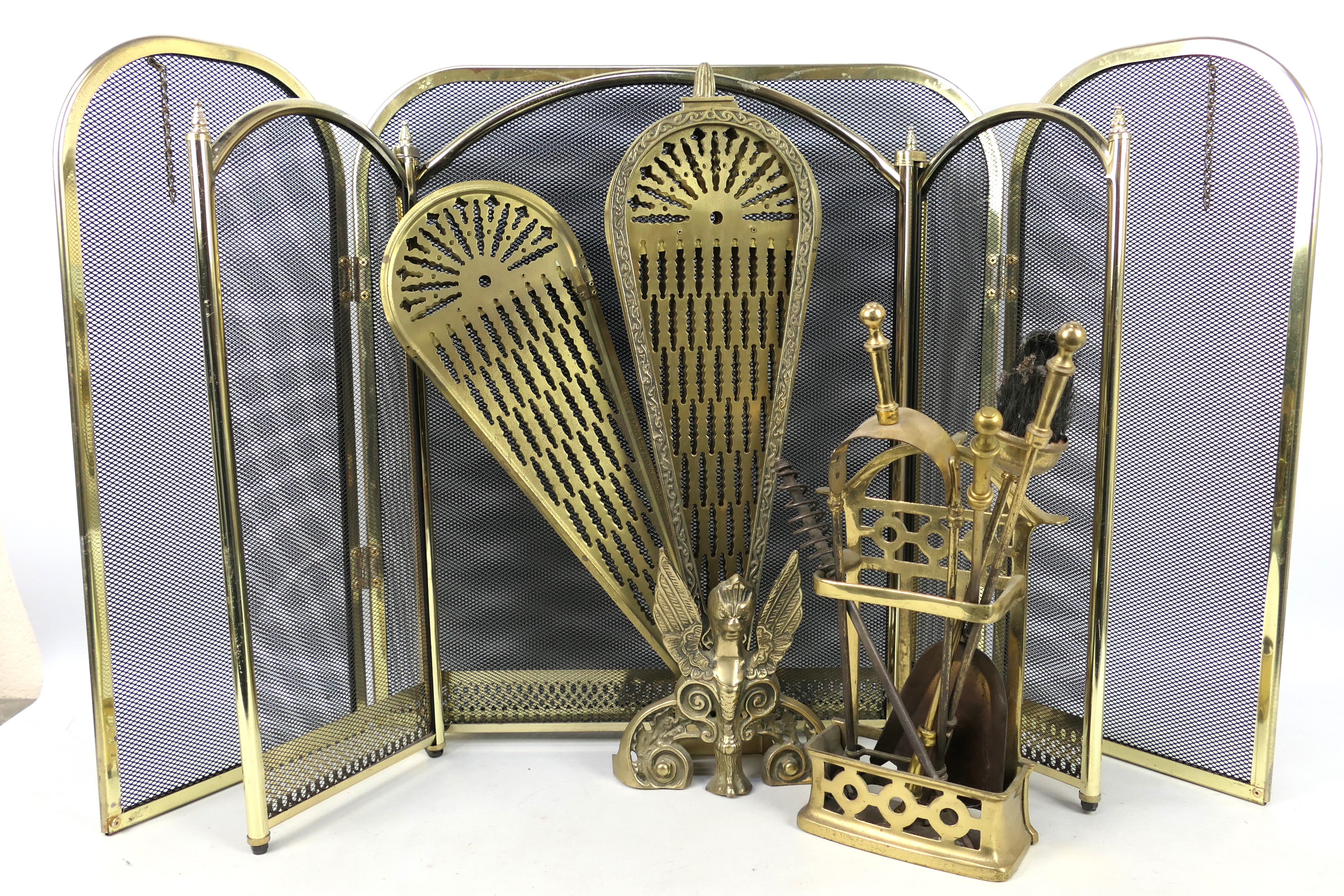 Three fire guards including a brass Peacock example and a brass fireside companion set.