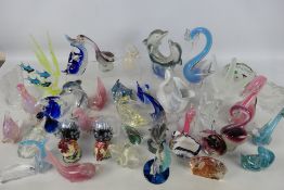 A quantity of glass, ceramic and other models of fish, dolphins and similar.
