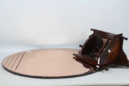 An Art Deco style oval wall mirror with peach tinted plate,