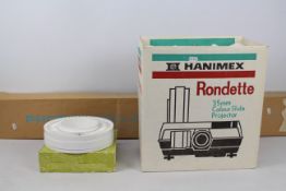 A Hanimex Rondette slide projector and a projector screen.