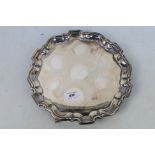 A silver salver with pie crust rim, raised on tripod scroll supports, Sheffield assay,